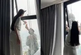 Mát lòng cảnh cô gái mời nước anh thợ treo mình giữa trời nóng lau kính cao ốc